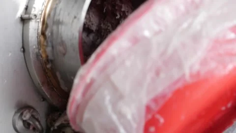 A metal grinder processes fish into paste inside a food production area with ind Видео 340890334