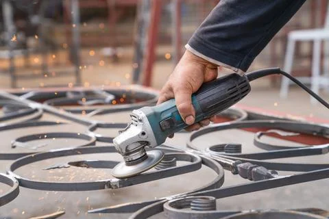 Metal grinding with angle grinder, side view. Stock Photos