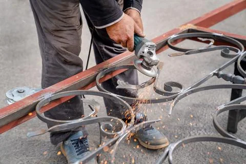 Metal grinding with angle grinder. Sparks fly on the sides. Stock Photos