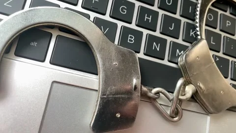 Metal Handcuffs on a Laptop Computer Keyboard Stock Footage 325464794