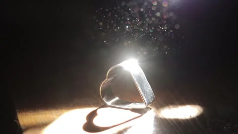 Metal heart in a ray of light Stockbeeldmateriaal 258845000