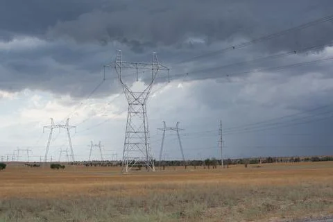 Metal high voltage structures against a gray sky Stock Photos