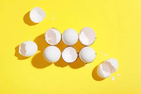 Metal holder with egg shells on yellow background Foto stock