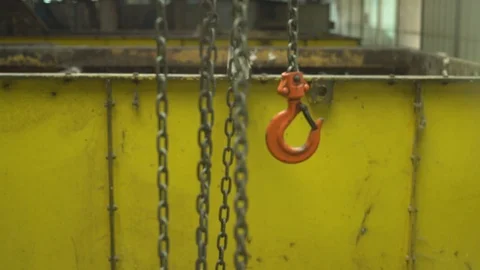 Metal hook on a chain on the background of huge metal containers at the factory Stock Footage 118930262