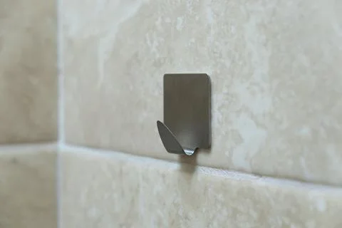 Metal hook for clothes on a tile. Wall hook for towels Stock-Fotos