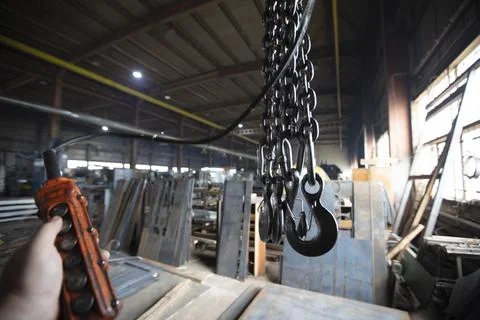 Metal industrial chains with hooks in the workshop of a metallurgical plant. Stock Photos