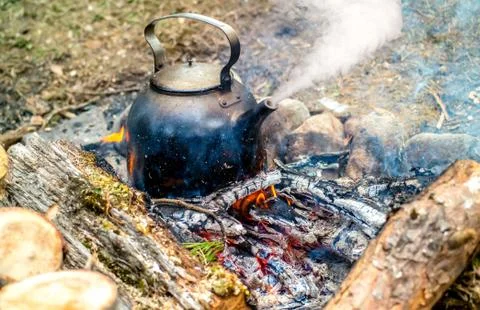 Metal kettle boiling on the fire Stock Photos