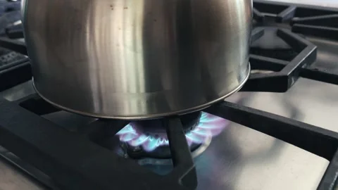 Metal kettle boiling water on active gas stove burner 库存影片 341143436