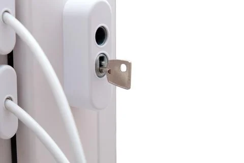 Metal key inside window lock mechanism. Secure latch on white plastic frame i Stock Photos