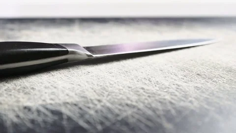 Metal Kitchen Knife On Scratched Table Reverse Panning Movement Closeup Stock Footage 77527936