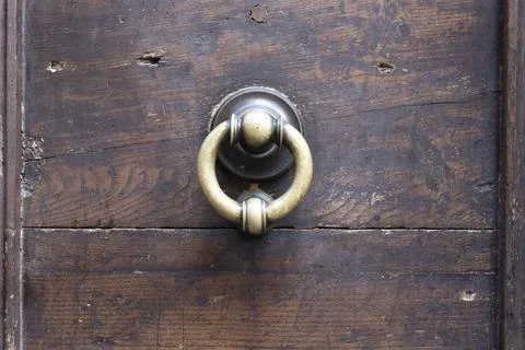 Metal knobs with decorative elements on a wooden door Stock Photos