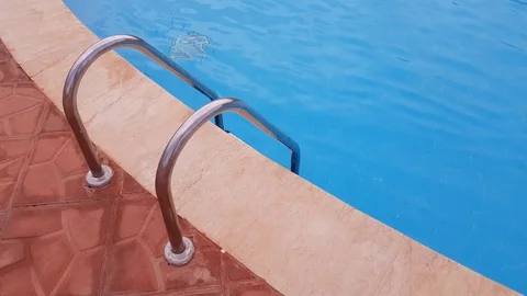 Metal ladder to the pool. in the pool is clear blue water. Stock Footage 127858818