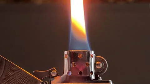 Metal Lighter Ignites a Steady Flame Producing a Soft Crackle and Pop Sound Stock Footage 328797012