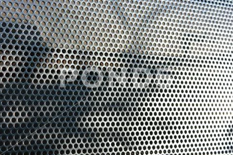 Metal mesh, background with round identical holes, metal structure shadow light Stock Photos