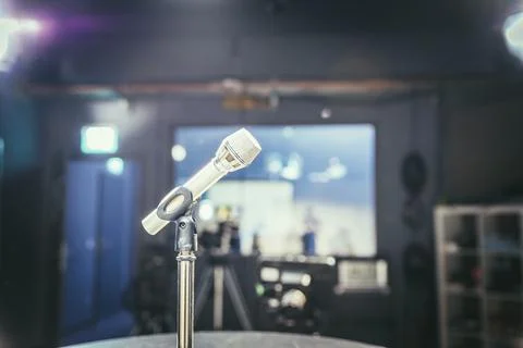 Metal microphone in the studio, studio lights in the blurry background Stock Photos