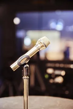 Metal microphone in the studio, studio lights in the blurry background Stock Photos