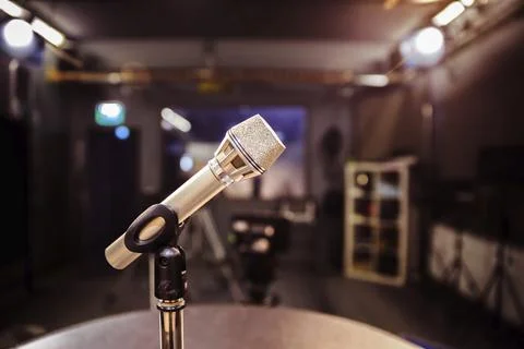 Metal microphone in the studio, studio lights in the blurry background Stock Photos