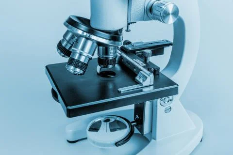 Metal microscope on blue background Stock Photos