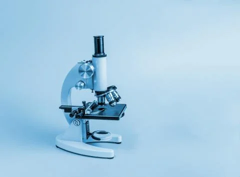 Metal microscope on blue background Stock Photos