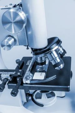 Metal microscope on blue background Stock Photos