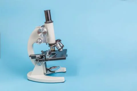 Metal microscope on blue background Stock Photos