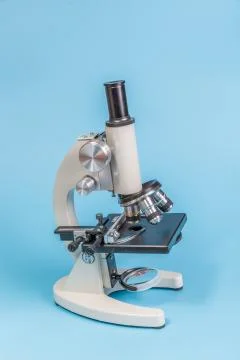 Metal microscope on blue background Stock Photos