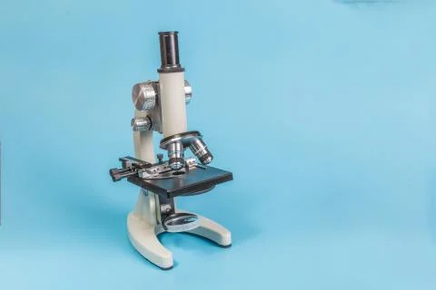 Metal microscope on blue background Stock Photos