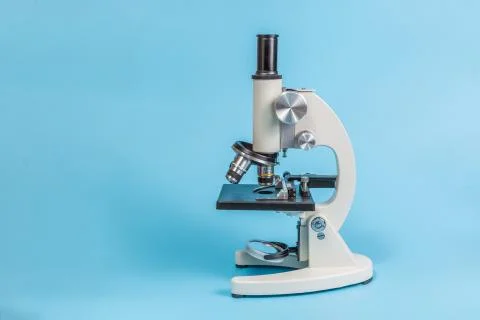 Metal microscope on blue background Stock Photos