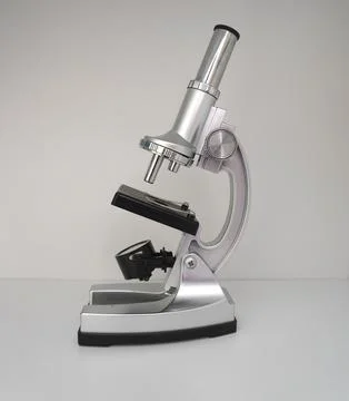 Metal microscope on a light background, side view, single object Stock Photos