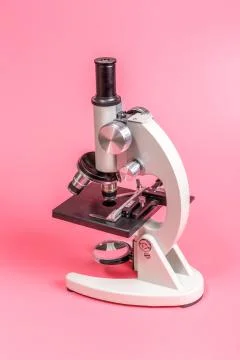 Metal microscope on pink base Stock Photos