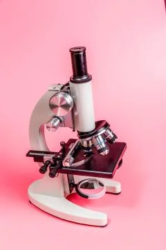 Metal microscope on pink base Stock Photos