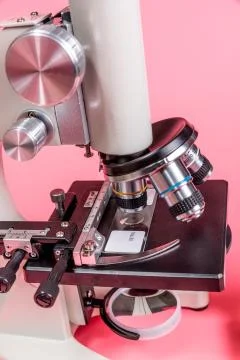 Metal microscope on pink base Stock Photos