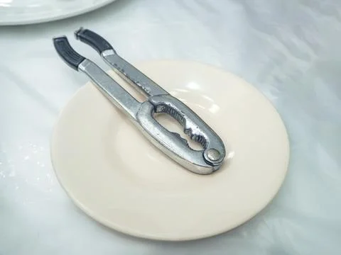 Metal nutcracker or crab cracker on a plate Stock Photos