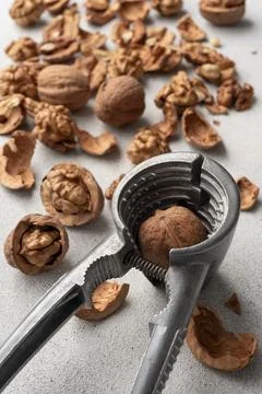 Metal nutcracker with scattered walnut shells. Minimal still life concept of  Stock Photos