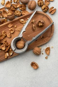 Metal nutcracker with scattered walnut shells. Still life concept of natural  Stock Photos