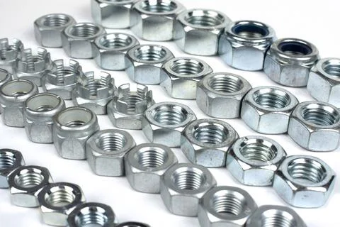Metal nuts of different sizes in several lines 스톡 사진