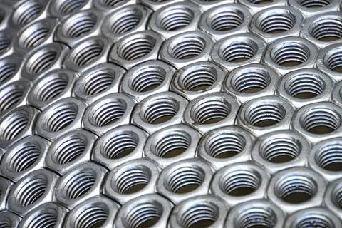 Metal nuts in a row background Stock Photos