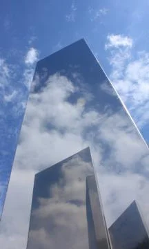 A metal object reflecting a blue sky with white clouds. Stock Photos
