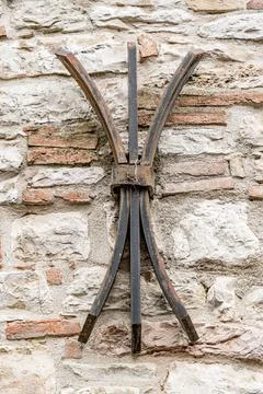 A metal object with three legs is attached to a wall in Gubbio Italy Umbria Foto stock