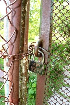 Metal padlock extra binary top security on the iron mesh gate Stock Photos