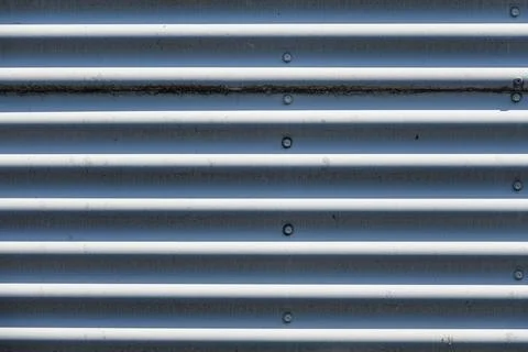 Metal panels arranged in a horizontal pattern exhibit a play of light and s.. Stock Photos