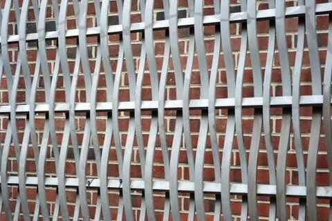 A metal pattern against a brick wall Stock Photos