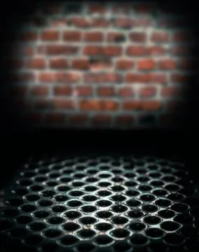 Metal perforated table surface in a dark basement against a brick wall close  Stock Photos