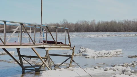 Metal pier over a river with floating ice during spring Stock Footage 332432373