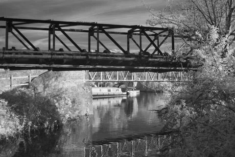 Metal pipe bridge structures reflected in canal water Stock Photos