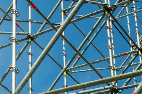 Metal pipe frame structure on blue sky background. Industrial construction fr 库存照片