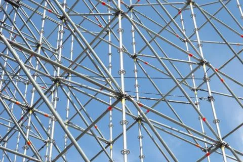 Metal pipe frame structure on blue sky background. Industrial construction fr Photos