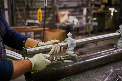 Metal pipe in the hands of a worker in the workshop for the manufacture of lamp Foto stock