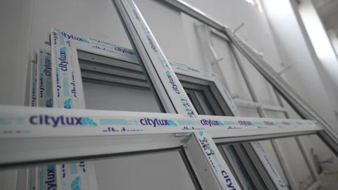 Metal plastic window frames with brand stickers near wall Stock Footage 312408794
