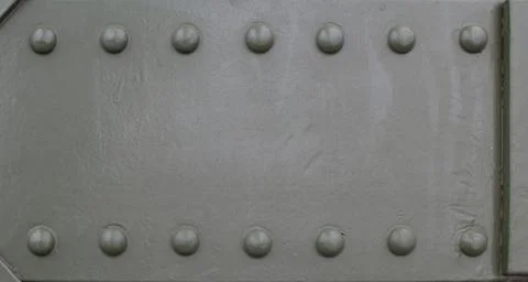 Metal plate with rivets on a structure showcasing industrial design Stock Photos